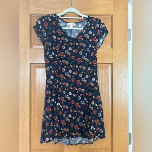 Adorable Blakely flower mini dress with pockets & criss cross tie on back.